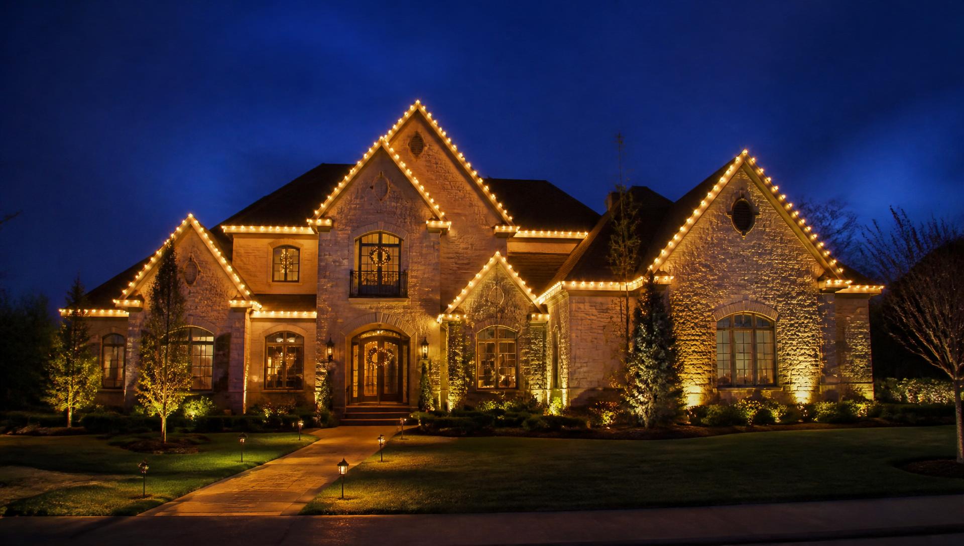 Home at dusk with warm professional roofline holiday lighting